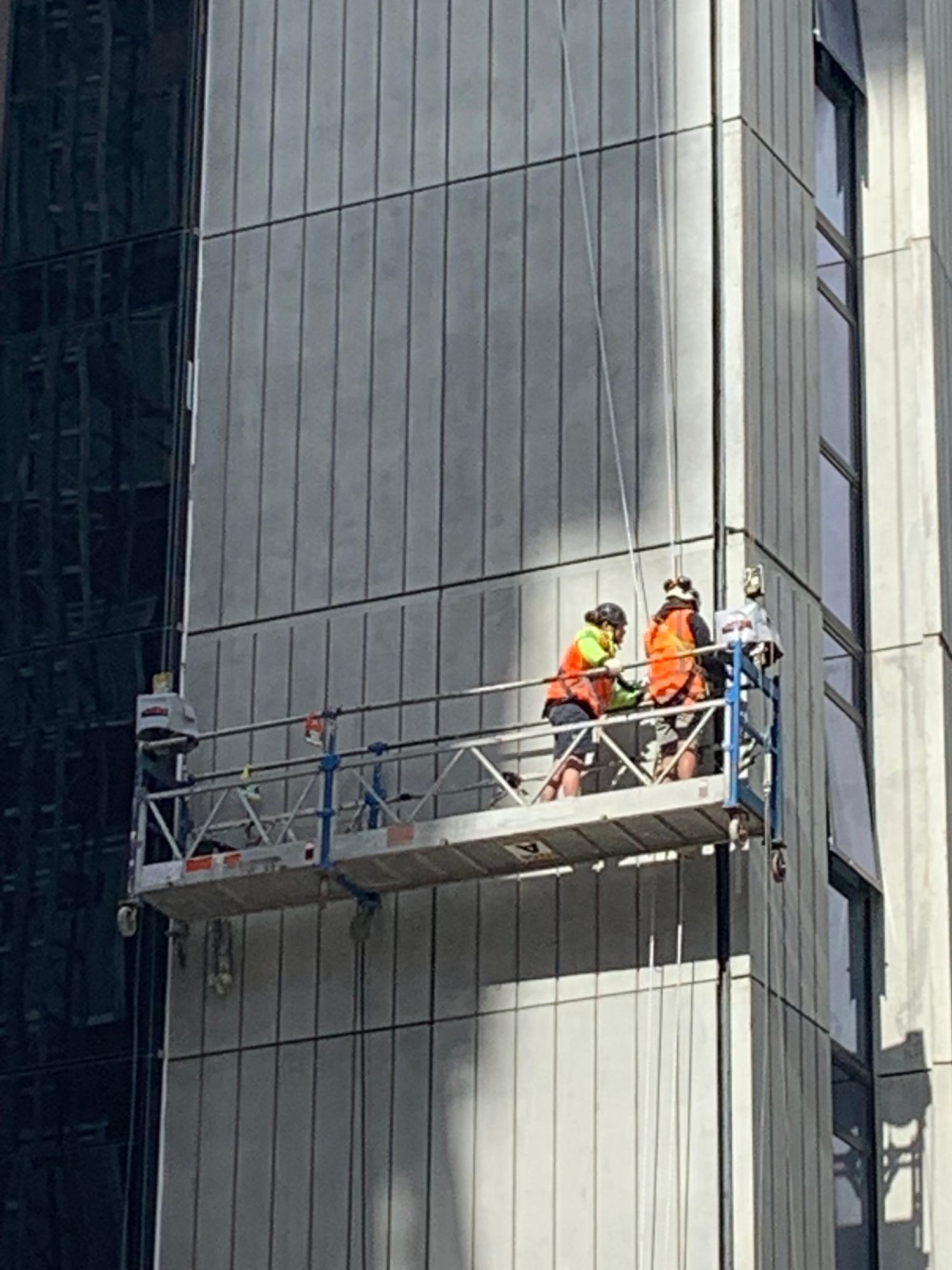 Installers on a swing stage fitting a seismic joint at Waiparuru Hall